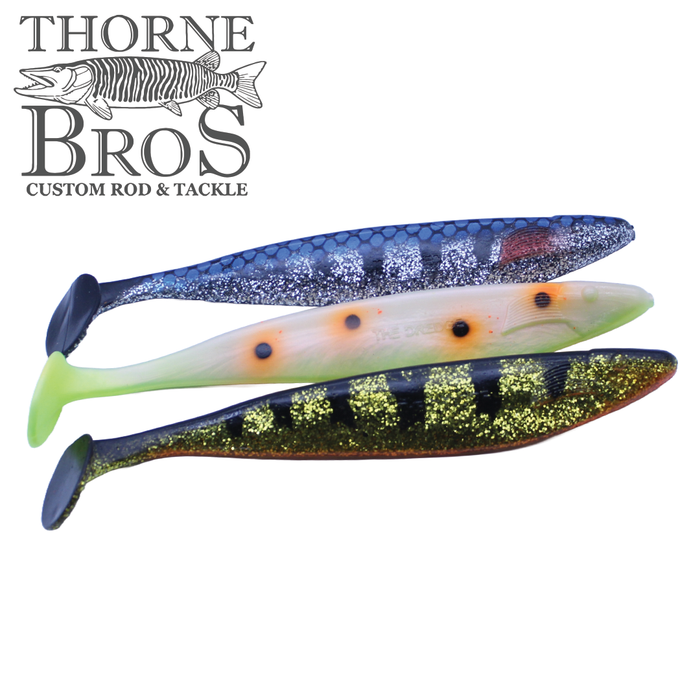 Three colorful soft plastic fishing lures in blue, white, and black with gold glitter, displayed against a white background, designed as Action Plastics 12" Dredge Shad.
