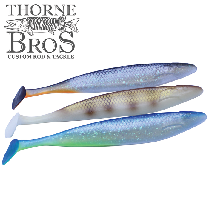 Three detailed soft plastic fishing lures in blue, brown, and green hues with paddle tails, labeled as Action Plastics 15" Shad - TB Custom, designed for musky fishing tackle.
