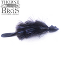 Black fishing lure with a textured tail and feathered body featuring iridescent dark fibers, designed for musky fishing, labeled Baby Beaver - Lake Edition by Thorne Bros.