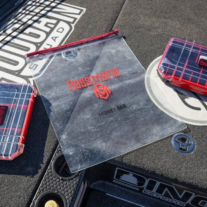 Clear waterproof Bass Mafia Money Bag with red logo and zipper, designed for securely storing fishing tackle and gear, displayed on a fishing boat deck.