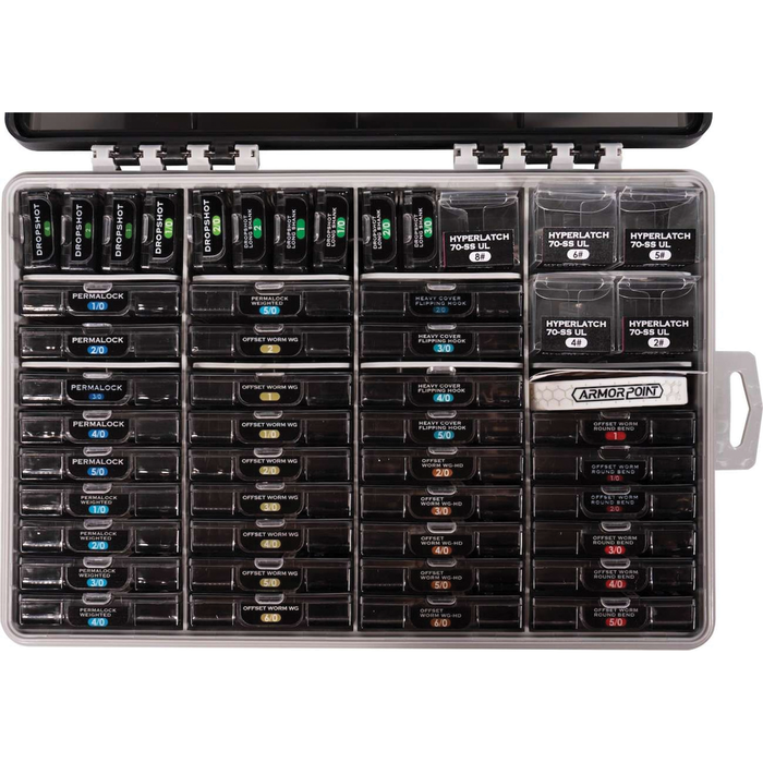 Top view of the BKK OCD Tackle Storage System (Fully Loaded) showing an organized, clear plastic tackle box with multiple compartments holding various fishing lures and tackle for fishing rods and reels.
