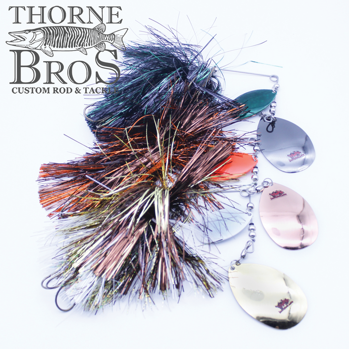 Blue Water Baits Gong Show 12 fishing lure with multiple metallic spinner blades in gold, copper, silver, and green, featuring a colorful, shiny skirt for attracting musky fish.