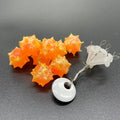 BnR Tackle BurrBeads Medium in bright orange with textured surface, accompanied by white plastic bait stops on wire, designed for fishing tackle and lure setup.