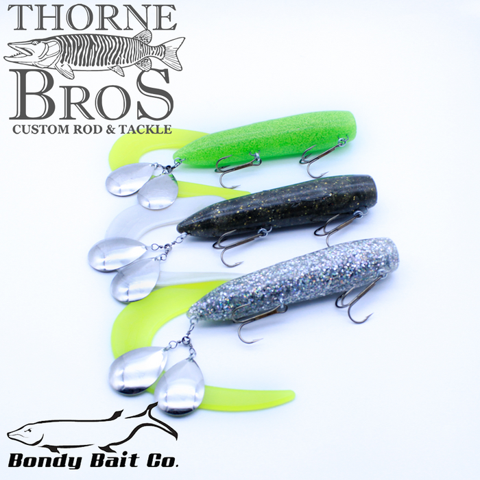 Three Bondy Royal Orba fishing lures in green, dark speckled, and silver glitter finishes, each equipped with treble hooks and metal spinner blades for musky fishing.