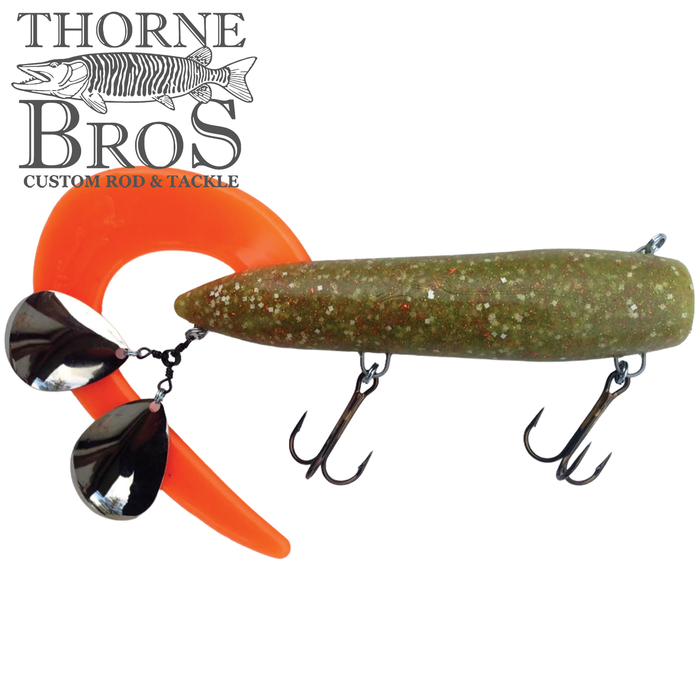 Bondy Royal Orba fishing lure with a green speckled body, bright orange curly tail, two silver spinner blades, and two treble hooks designed for musky fishing.