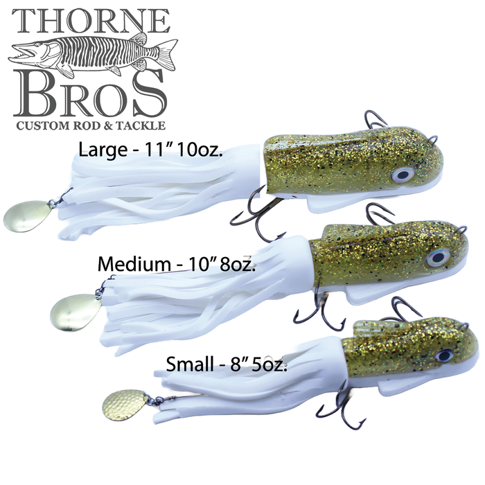 Three Boss Shad Medium Hybrid fishing lures in large, medium, and small sizes, featuring gold and white color with multiple hooks and skirted tails designed for musky fishing.