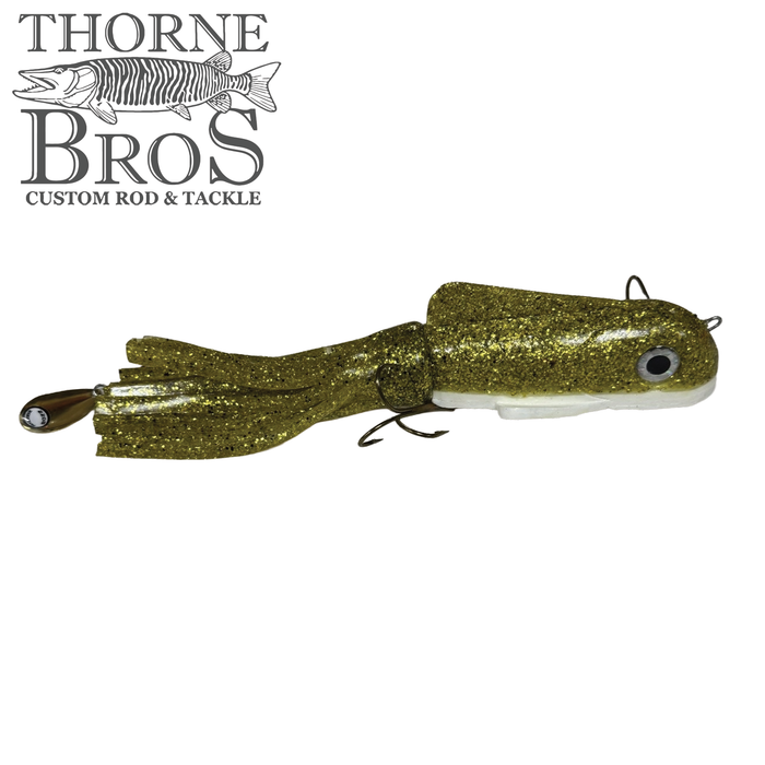 Gold glitter fishing lure with white underbelly and realistic eye detail, featuring multiple hooks and flexible tail, designed as the Boss Shad Medium Hybrid for musky fishing.