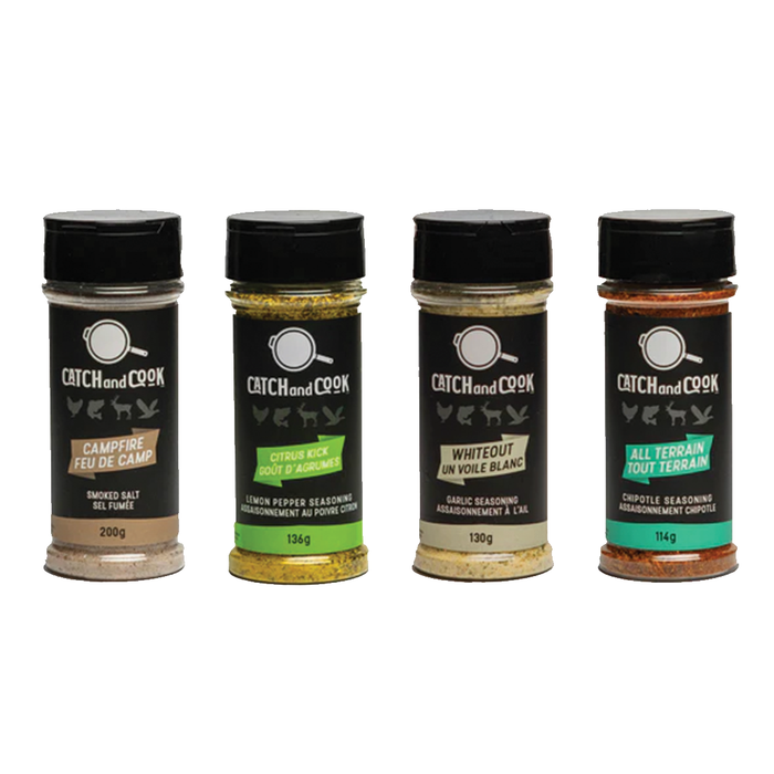 Four clear spice jars with black lids labeled Catch & Cook Spices featuring Campfire smoked salt, Citrus Kick lemon pepper, Whiteout garlic seasoning, and All Terrain chipotle seasoning, each with animal icons on the label.