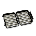 Open black and gray C&F Design Fly Boxes with foam inserts featuring multiple rows of slotted grooves for securely holding fishing flies and tackle.