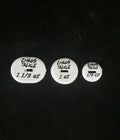 Three white round weighted fishing tackle pieces in varying sizes labeled Chaos Deep Threat Weights with weight markings 1 1/2 oz, 1 oz, and 1/2 oz on a black background.