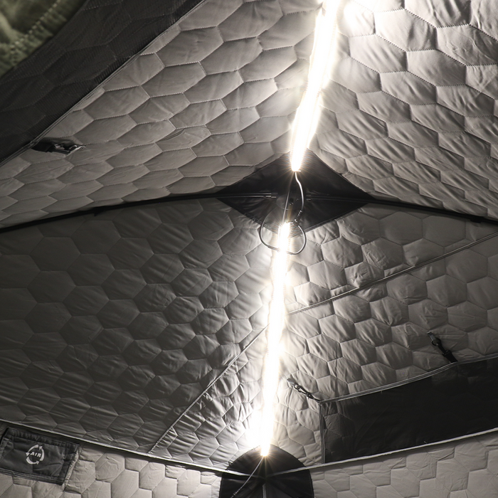 Interior view of an insulated fishing shelter ceiling illuminated by a bright strip of Clam Aurora LED Light Kits, enhancing visibility during ice fishing activities.