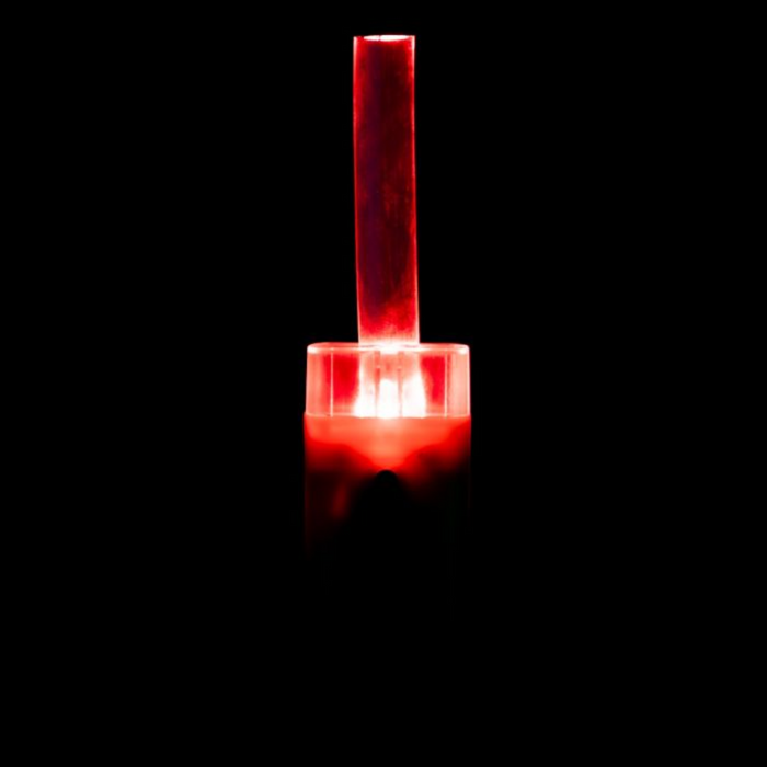 Clam Nite Bite Tip Up Light glowing red in darkness, designed for ice fishing to signal fish bites with bright visibility for anglers.