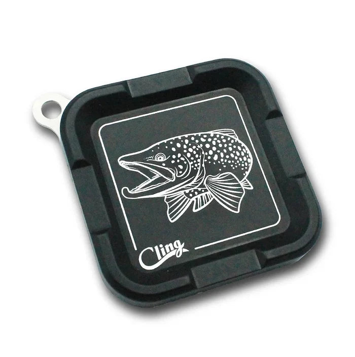 Black square magnetic tackle tray with a white detailed fish illustration and the words Cling Mag Grab Plus printed on the surface, designed for securely holding fishing lures and small gear.