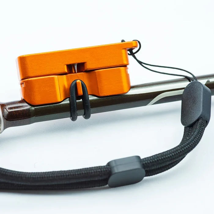 Cling Mag Grab Rod Rack in bright orange attached to a fishing rod, designed for secure holding and easy transport, featuring a black adjustable wrist strap for convenience.