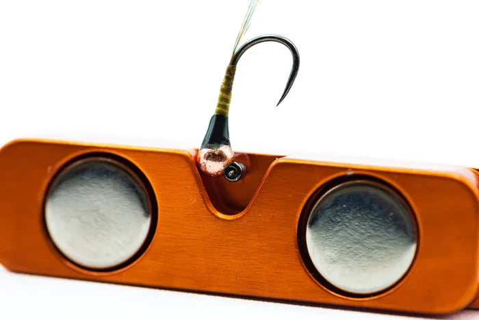 Cling Mag Grab Rod Rack featuring a close-up of an orange magnetic holder with two silver magnets securing a fishing hook, designed for organizing fishing tackle.