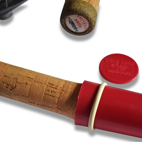 Close-up of a cork fishing rod handle with a red Cold Snap Reel Wrap - Pro Pack fitted around the reel seat, showing the product's protective design and included red cap next to it.