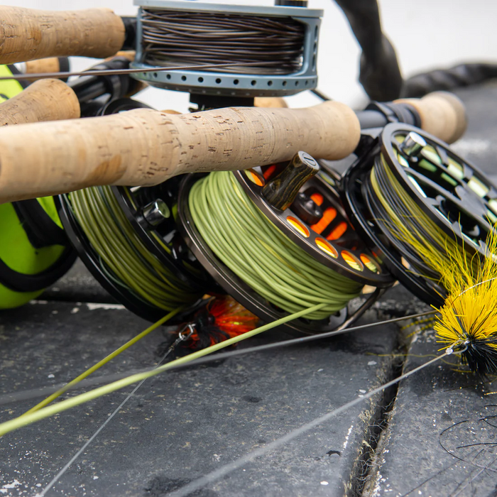 Close-up of fishing rods and reels with green and dark fly lines, featuring Cortland Pike/Musky Float Fly Line used for musky and pike fishing tackle.