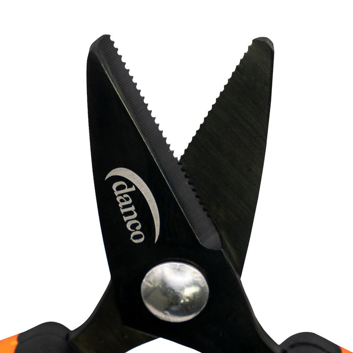 Close-up image of Danco Lunar-1 Serrated Braid Scissors showing black serrated stainless steel blades and a silver pivot joint with part of the orange and black handle visible.