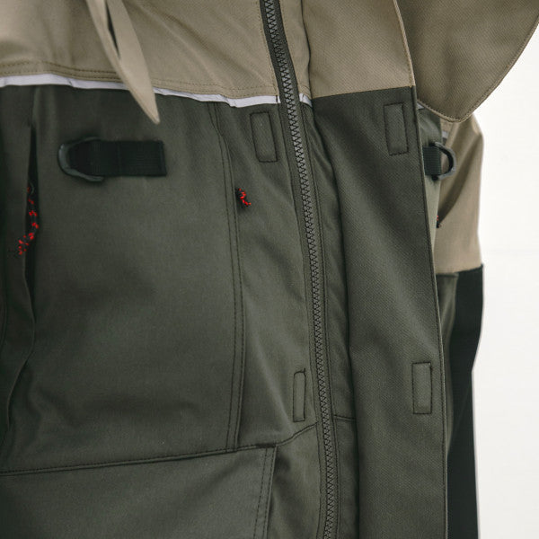 Close-up of the front zipper and pocket area on the Eskimo Expedition Jacket - Men's, featuring durable two-tone fabric in olive green and beige with red zipper pulls.