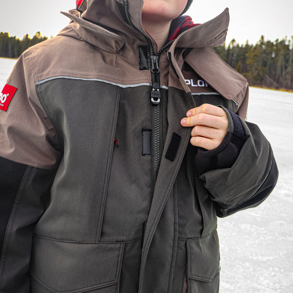 Youth wearing a two-tone brown and gray Eskimo Explorer Jacket - Youth with a hood and zipper closure, designed for cold weather outdoor activities like fishing.