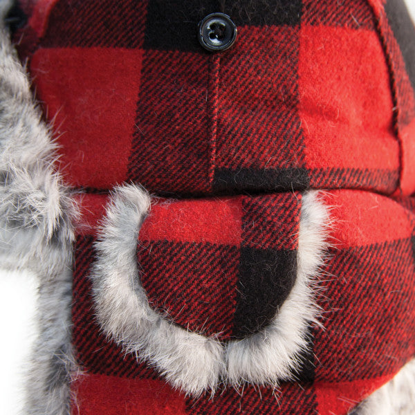 Close-up of a red and black plaid Eskimo Plaid Alaskan Fur Hat featuring soft gray fur trim and a button detail, designed for warmth in cold outdoor conditions.