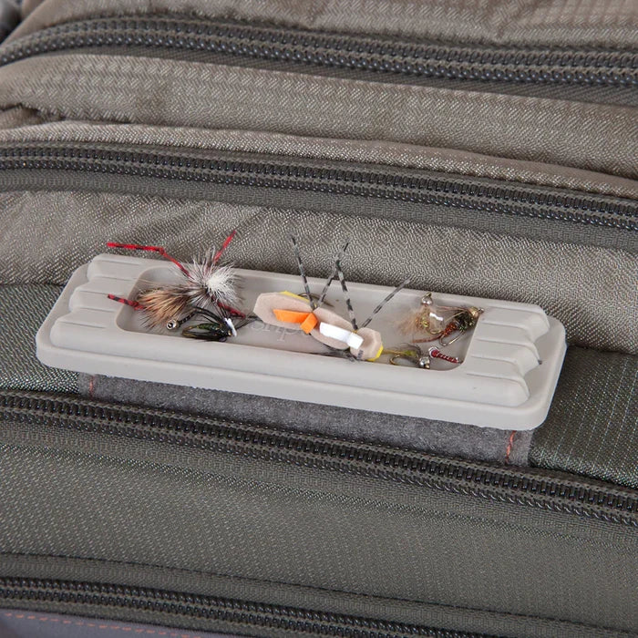 Fishpond Tacky Fly Doc MagPad attached to fishing bag, holding various fishing flies and lures for easy access and organized fishing tackle.