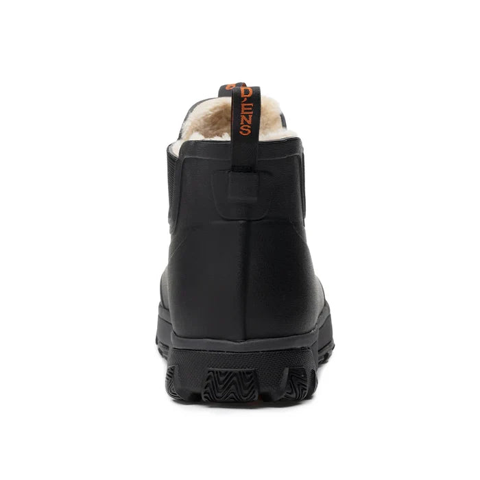Grundens Deviation Sherpa Ankle Boot shown from the rear, featuring black waterproof exterior, thick rugged sole, and warm cream-colored sherpa lining visible inside.