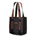 Grundens Shoreman Tote Bag in black with durable construction and long handles featuring orange Grundens branding, designed for carrying fishing tackle and gear.