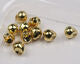 Close-up of multiple small, shiny, gold-colored Hareline Insta-Jig Tungsten Head fishing tackle jig heads used for fishing lures and tackle.