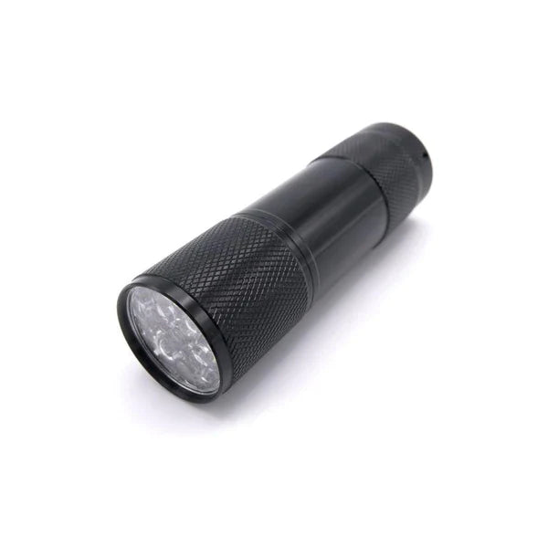 Compact black handheld flashlight with textured grip and multiple LED bulbs on the front, designed as the Hareline Universal UV Cure Light for fishing tackle use.