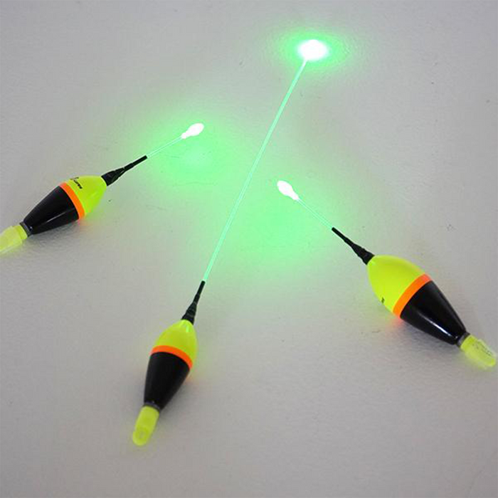 Three JB Lures Lighted Fire Float fishing tackle pieces in black, yellow, and orange with thin illuminated green light sticks extending from each float for enhanced visibility in low light.
