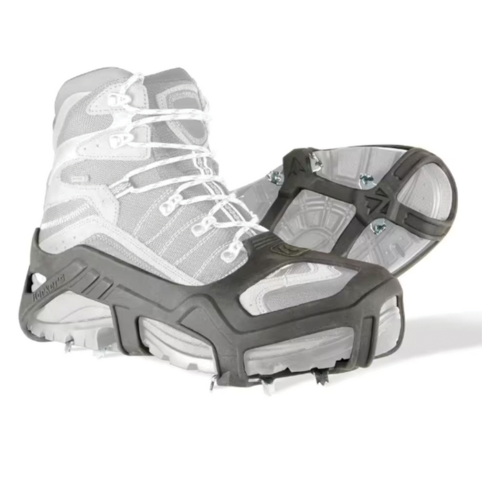 Pair of black Korkers Apex Ice Cleats designed to securely attach over boots, featuring metal spikes for enhanced traction on ice and snowy surfaces.