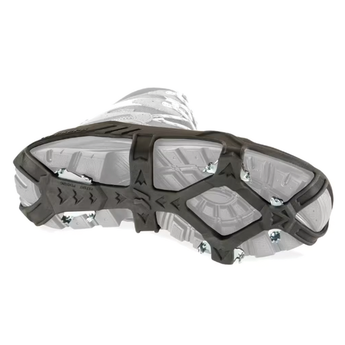Korkers Apex Ice Cleats shown attached to the sole of a white boot, featuring black rubber straps and metal spikes designed to provide traction on ice for outdoor fishing activities.