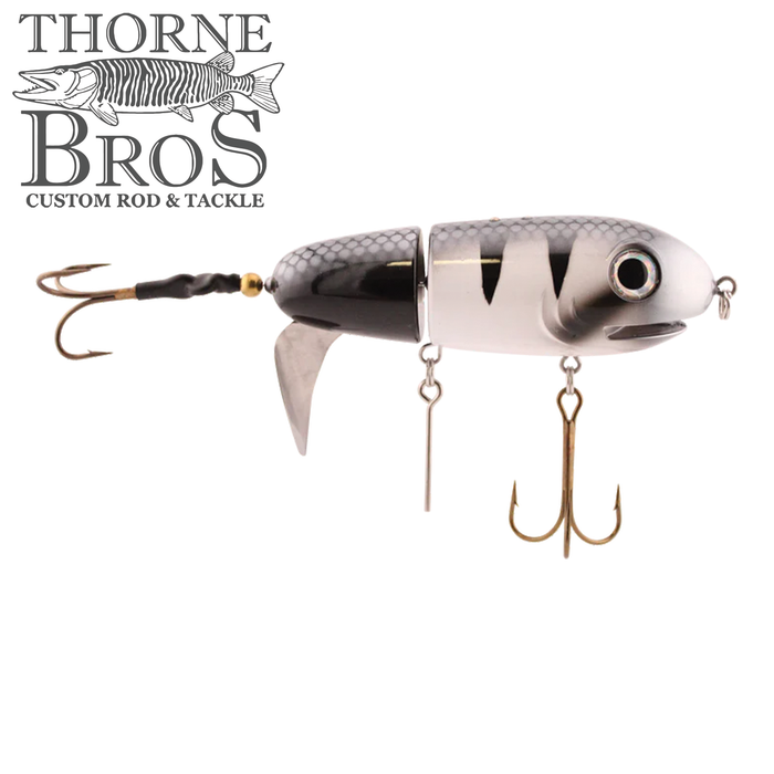 Livingston Lures Big Makk fishing lure in silver and black with realistic fish scale pattern, two treble hooks, and a curved metal fin for attracting musky and other large fish.