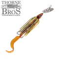 Livingston Lures Kamakaze featuring a metal blade, detailed fish head, multi-colored skirt, and curly tail designed for effective fishing tackle and lure action.