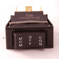 Close-up of a black rocker switch with white lettering displaying "MOM," "OFF," and "CON" positions, identified as Minn Kota SWITCH-MOM/OFF/COM [C016 P/N:2254031, suitable for fishing tackle and marine electronics.
