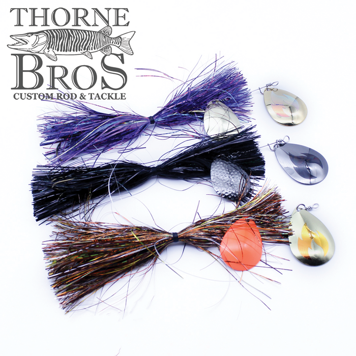 Three Musky Addicts Barn Burner 8/7C fishing lures with colorful skirts in purple, black, and brown, each paired with a shiny metallic spinner blade for musky fishing tackle.
