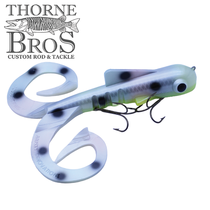 Musky Innovations Double Dawg - Super Magnum (Pounder) fishing lure with a curved, translucent white body featuring black spots, lifelike eyes, and multiple treble hooks for musky fishing.