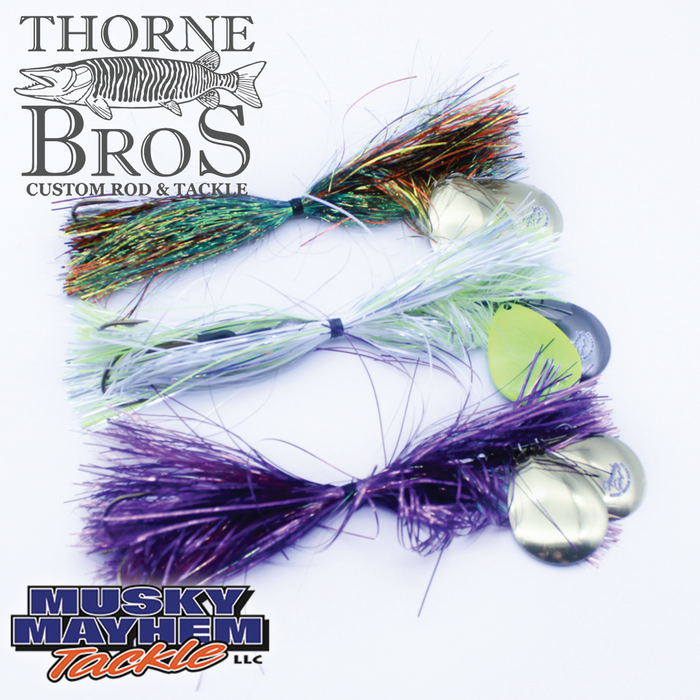 Three colorful Musky Mayhem Squeeky Girl fishing lures in green, white, and purple with flashy synthetic fibers and metal blades designed for musky fishing.