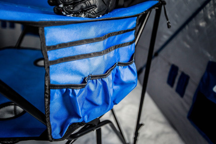 Close-up of blue fabric side organizer attached to the Otter Deluxe Double Decker Table - #201622, showing multiple zippered and open pockets designed for convenient storage during fishing activities.