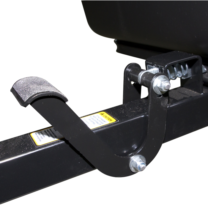 Close-up view of a black Polar Foot Pedal Latch made of metal with a textured foot pad, spring mechanism, and bolts, designed for secure pedal locking in fishing tackle gear.