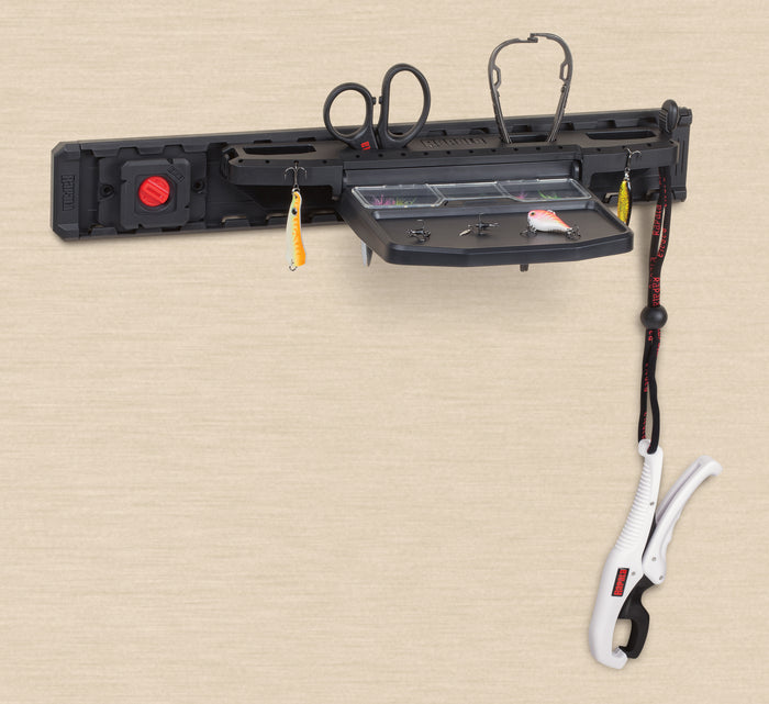 Rapala Smart Hub Workstation mounted on a wall with fishing scissors, lures, and a fish gripper attached, designed for organizing fishing tackle and tools.