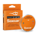 Spool and packaging of Seaguar Pounce Fluorocarbon fishing line in bright orange with branding and product details highlighting its strength and abrasion resistance for bass fishing use.