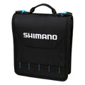 Black compact Shimano Baraja Tackle Bags with a top handle, blue zipper pulls, and white brand logo, designed for organized fishing tackle storage and easy transport.