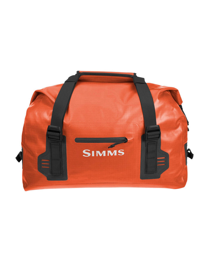 Simms Dry Creek Duffel in bright orange with black straps, featuring a front zipper pocket and durable waterproof material designed for fishing tackle and gear storage.