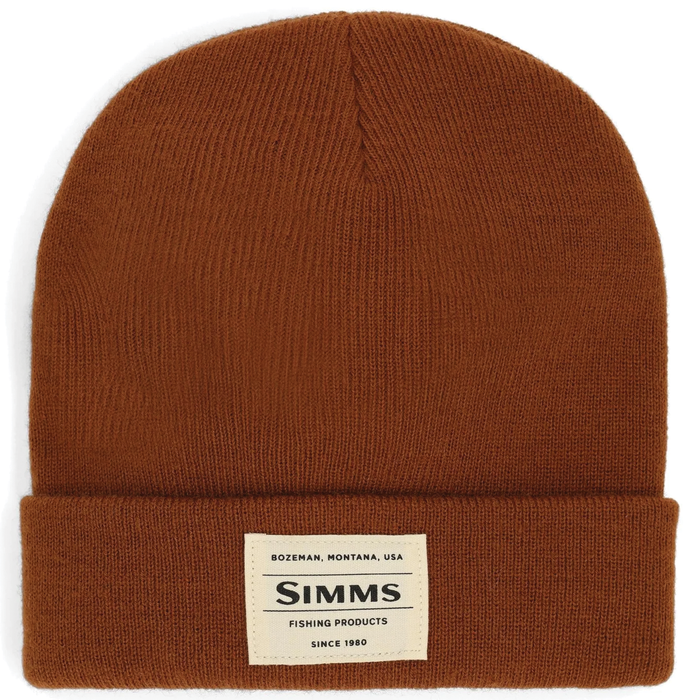 Simms Everyday Watchcap in warm brown knit fabric with a folded brim and a rectangular beige label displaying Simms branding and location details.