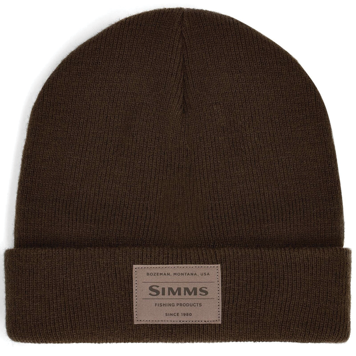 Simms Everyday Watchcap in dark brown knit fabric with folded cuff featuring a stitched leather patch labeled Simms Fishing Products, designed for outdoor fishing comfort.