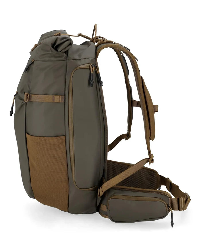 Simms Headwaters Backpack in earthy tones with multiple zippered compartments, padded shoulder straps, and adjustable hip belt, designed for fishing tackle and outdoor use.