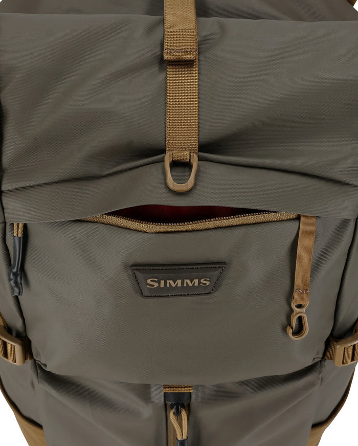 Simms Headwaters Backpack in olive green with multiple zippered compartments, adjustable straps, and durable fabric designed for fishing tackle and outdoor use.