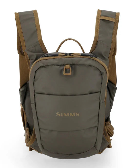 Simms Headwaters Chest Pack in olive green with brown trim, featuring padded adjustable shoulder straps, front zippered compartment, and durable fabric designed for fishing tackle storage and outdoor use.